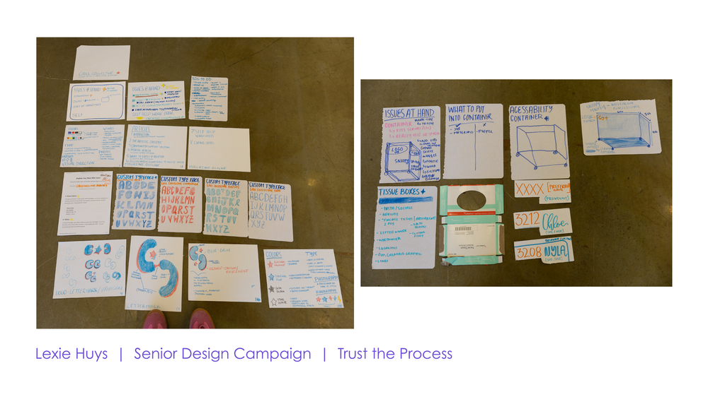Student senior design campaign sketches and wireframes spread across a table, showcasing the trust the process design workflow.