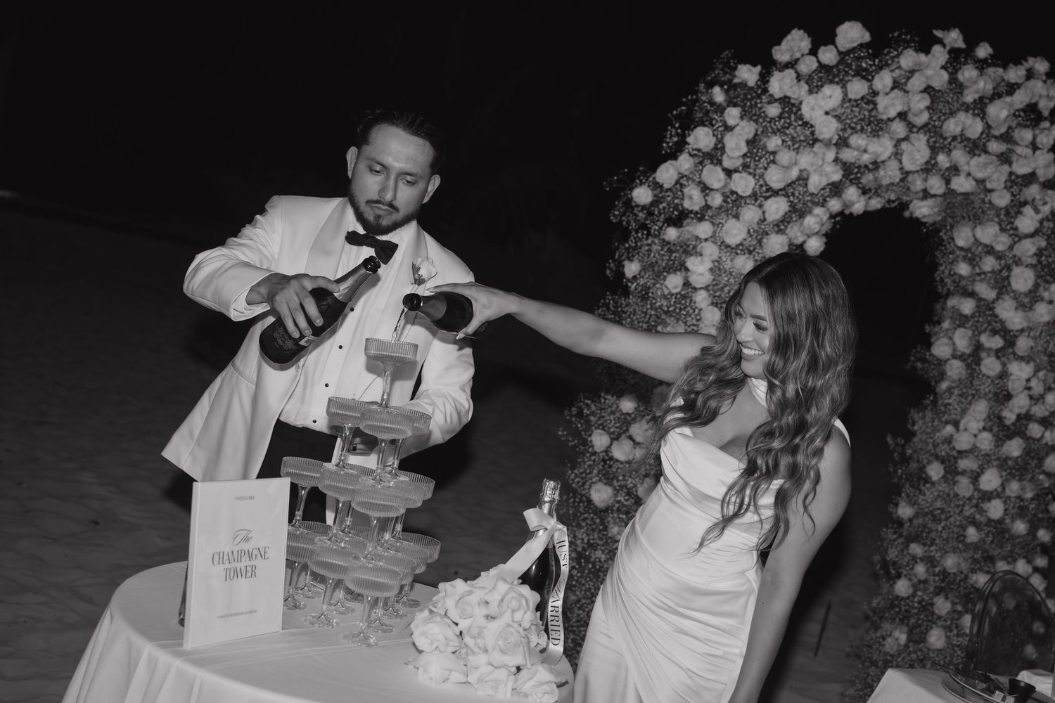 Bride and groom doing a champagne tower during their wedding reception at Costa Mujeres, Mexico.
