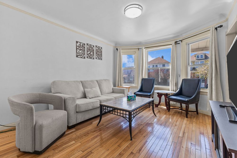 Living room with bay windows and hardwood floors in Dearborn Michigan bungalow