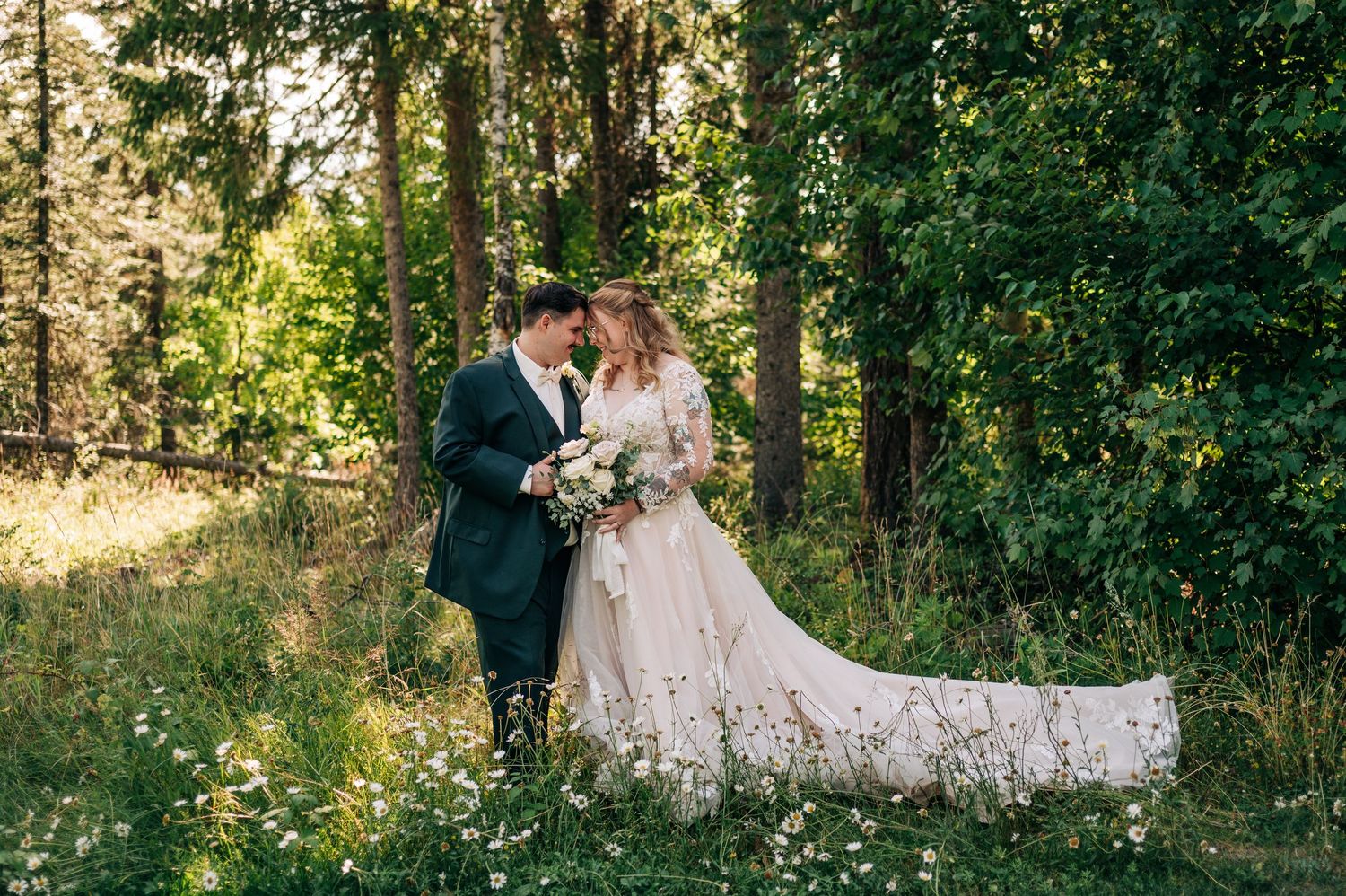 Bride and groom share a romantic moment in a lush forest clearing, bride in elegant white gown holding a bouquet.