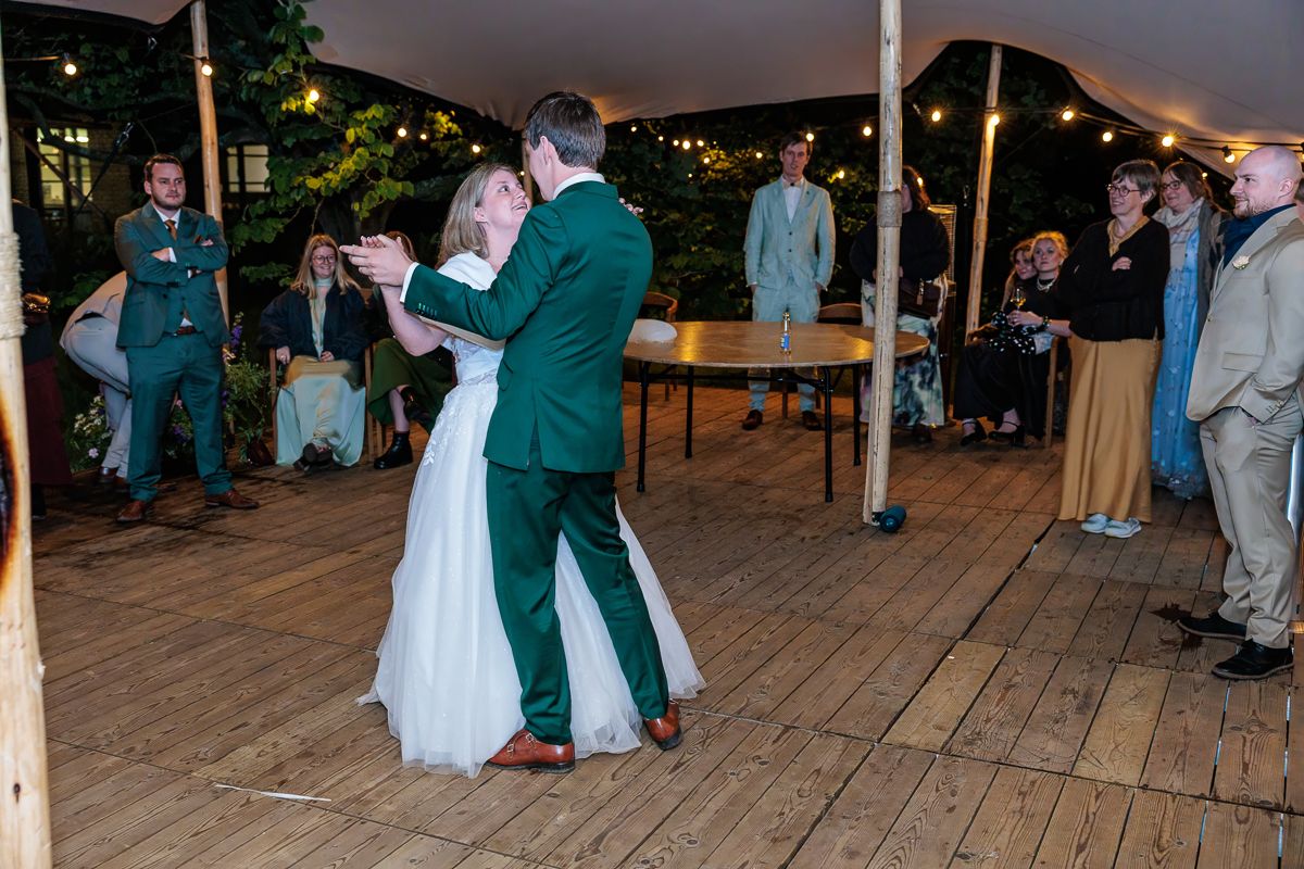 A romantic moment between newlyweds in a convertible car with feet visible.