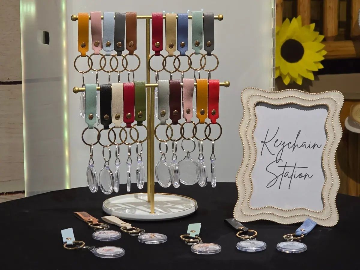 Colorful leather keychain display stand at a keychain station craft fair booth with sunflower decor.