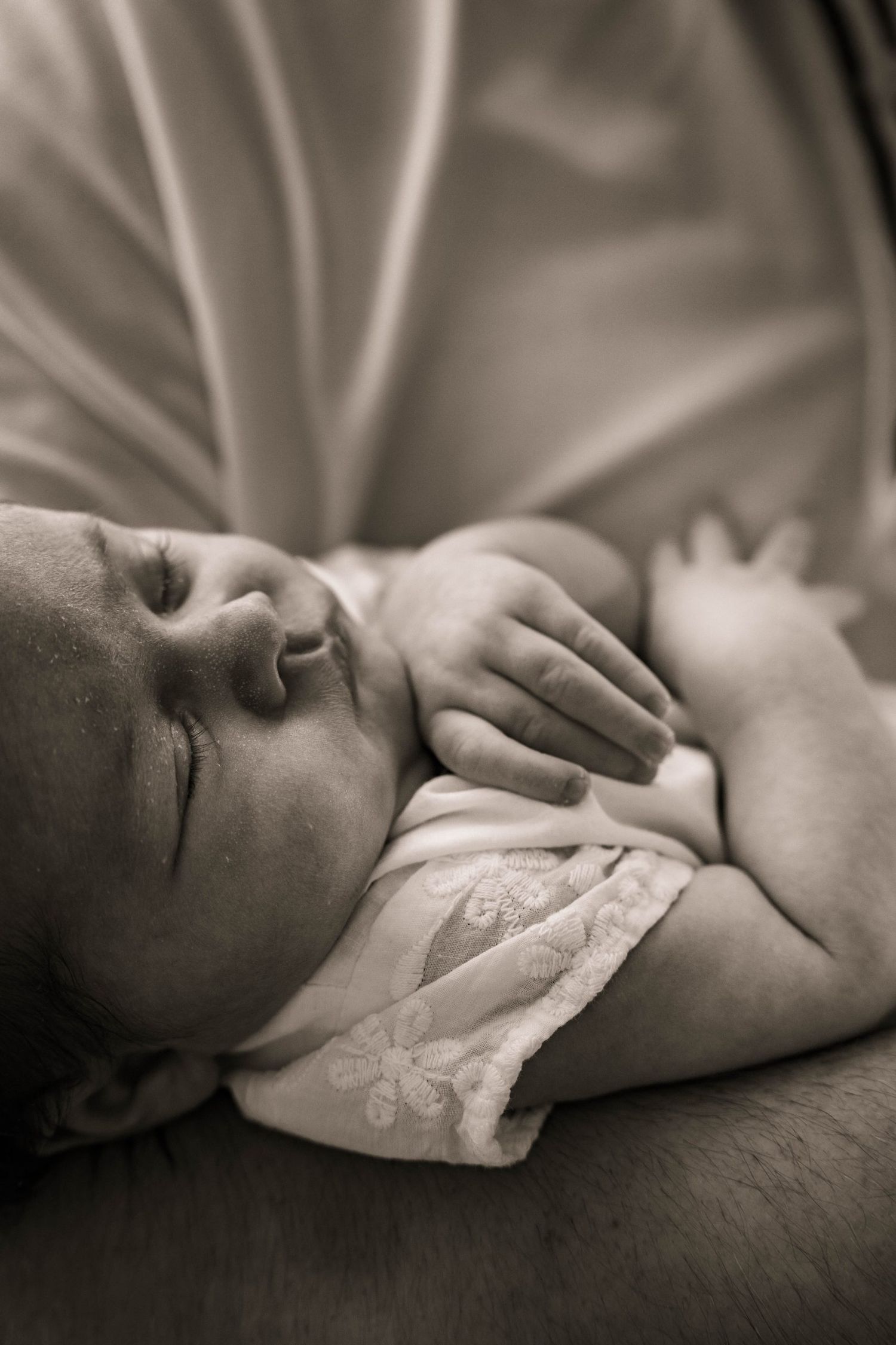 Black and white portrait of sleeping newborn baby in soft lighting.