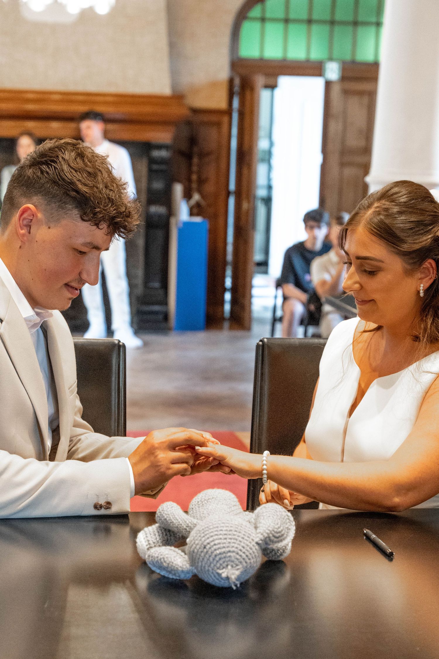 Wedding ceremony scene with small stuffed animals on a dark wooden table.