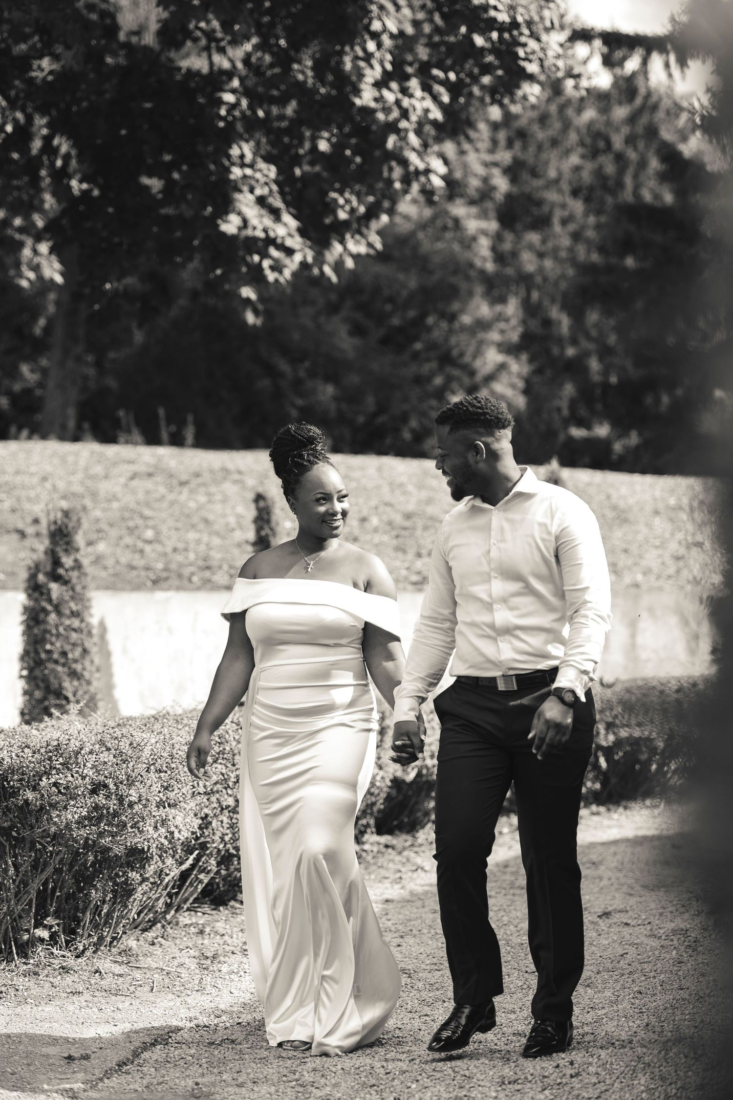 Beautiful Couple walking down a garden admring each other in the warm sun