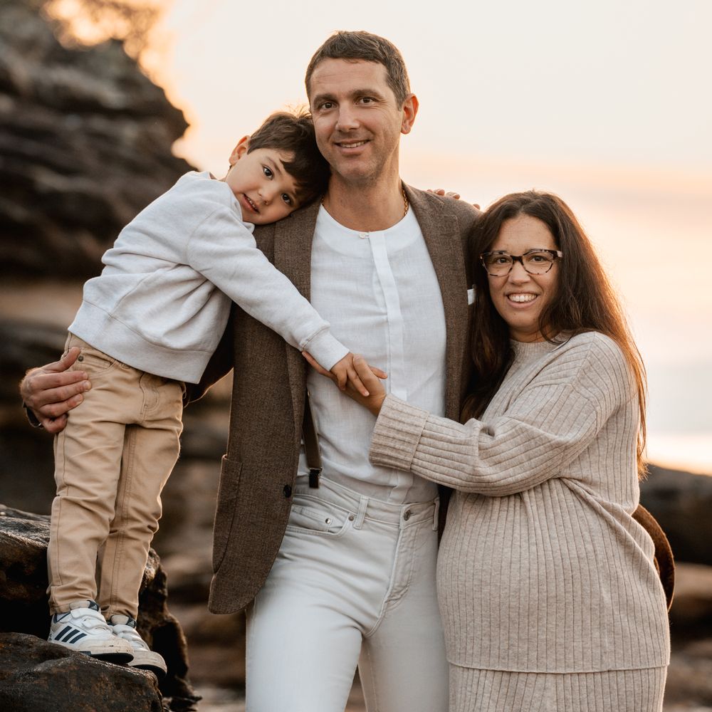 son-hugging-dad-and-mom-holds-son-hand-during-a-family-photoshoot-in-sydney