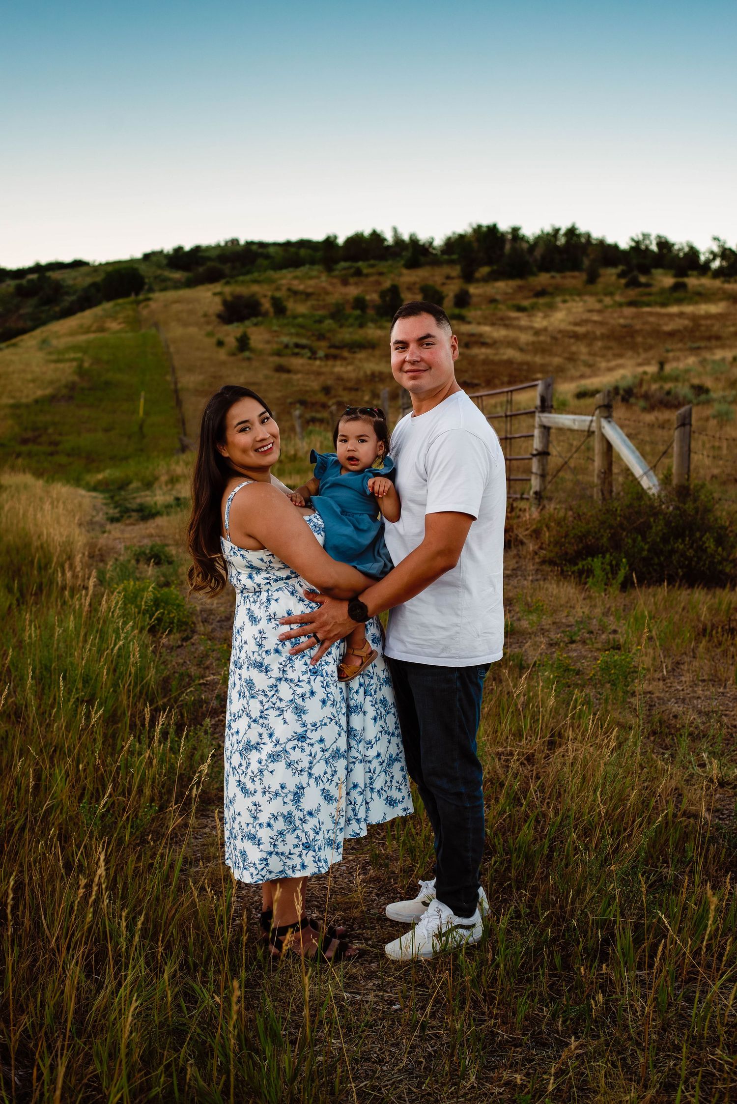 family embracing their daughter while looking out into the fields at Snow Basin, Utah