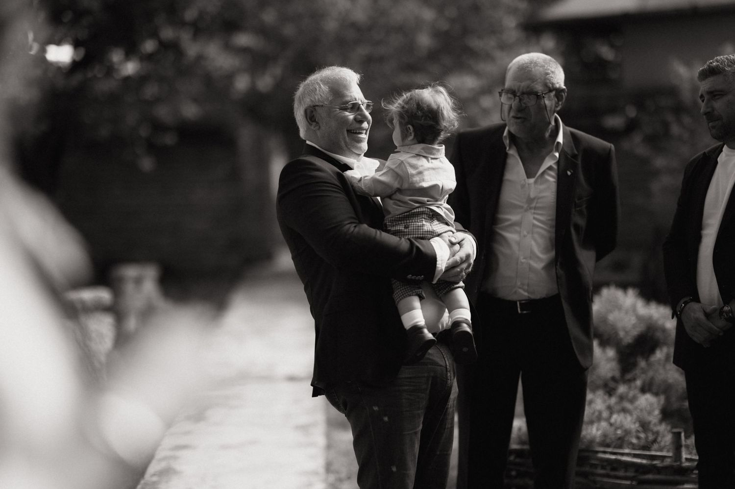 A black and white photo montage showing multiple candid moments at what appears to be a family gathering or celebration.