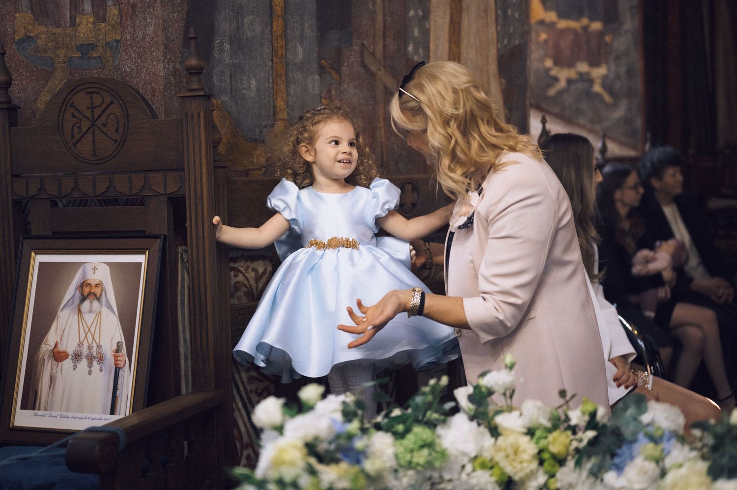 A tender moment inside a church with decorative walls and floral arrangements.