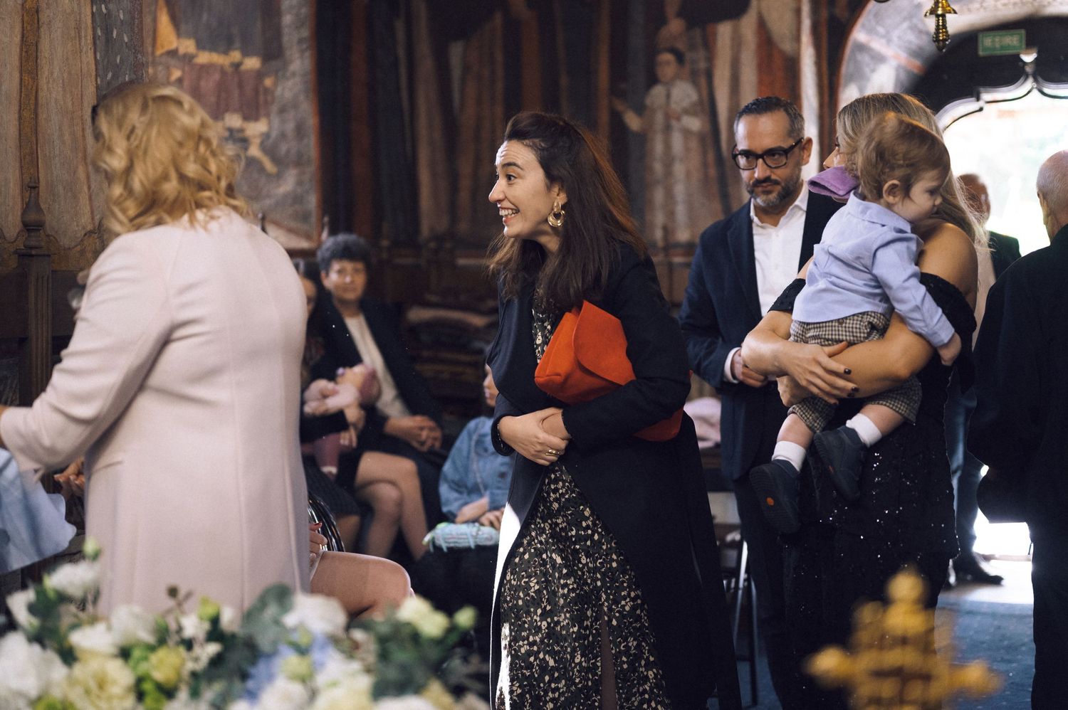 A couple embraces during their first dance at an elegant wedding reception surrounded by guests.
