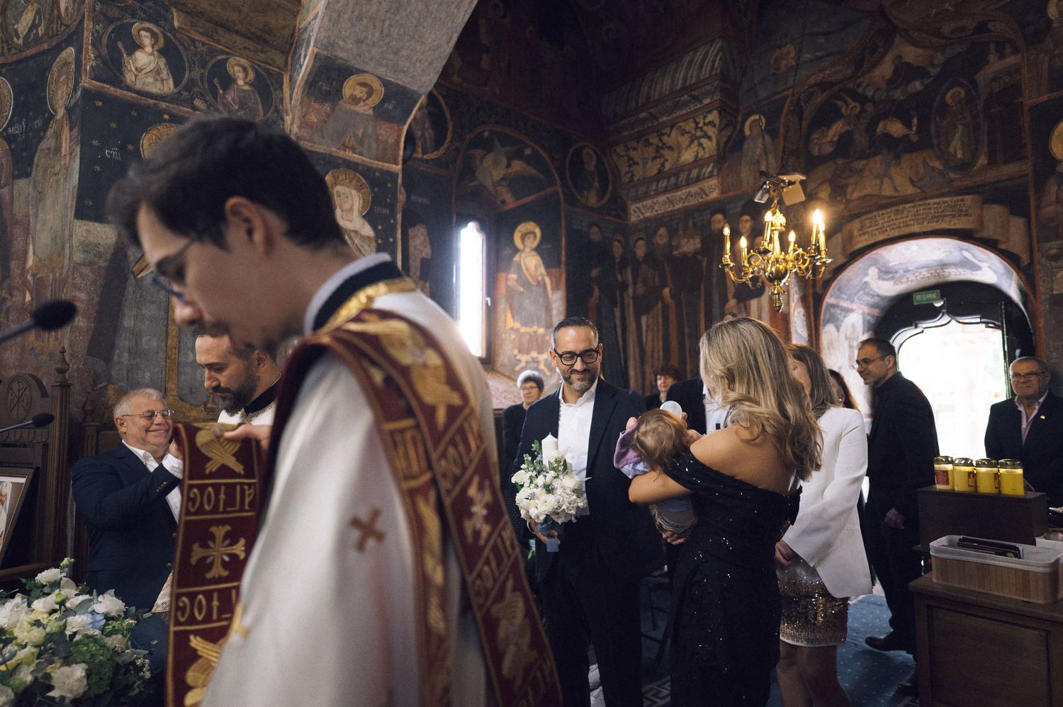 Elegant wedding ceremony inside a historic church with ornate decor and candlelit chandeliers.