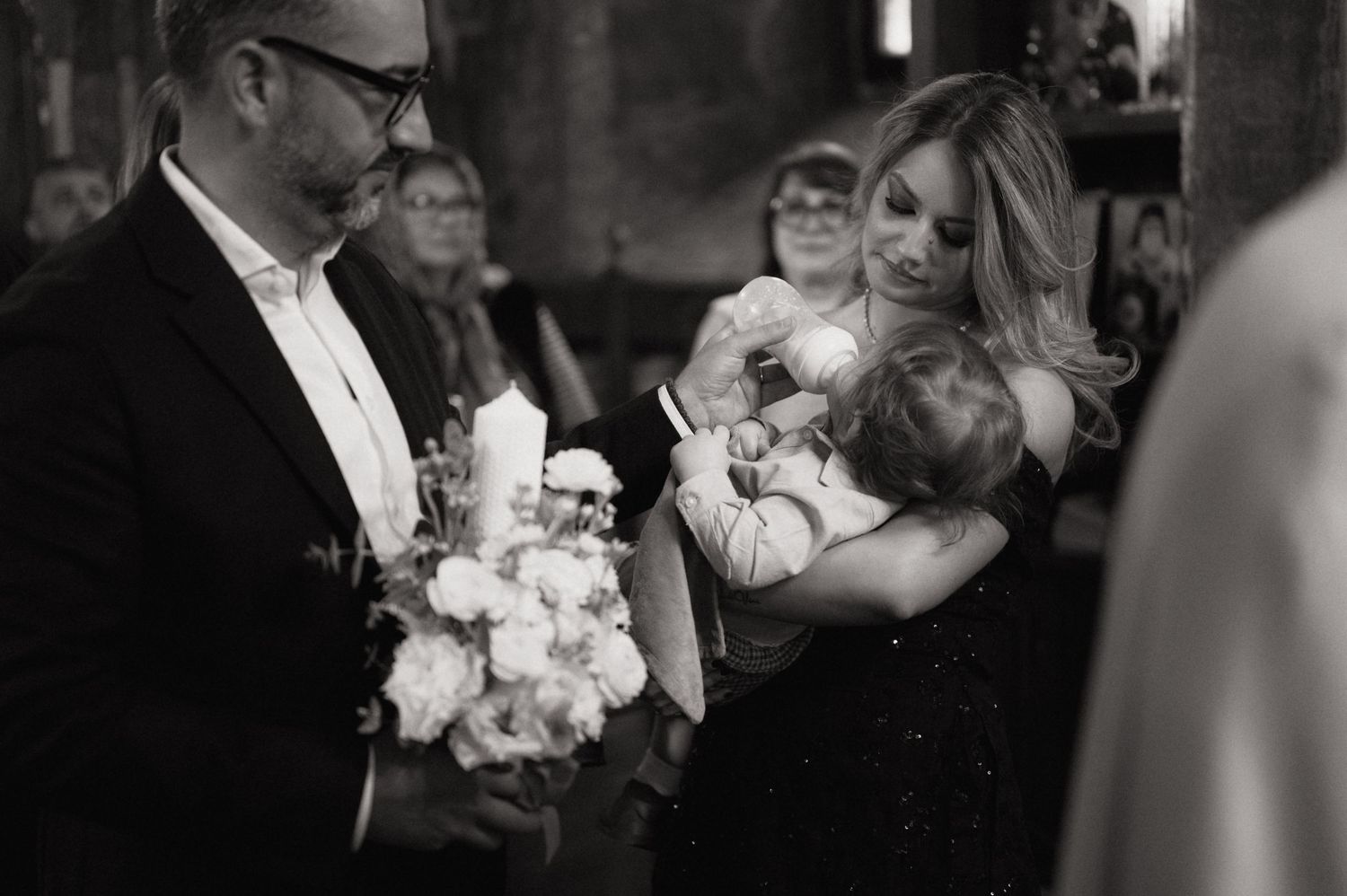 Black and white wedding photos showing emotional moments between guests and couples during a celebration.