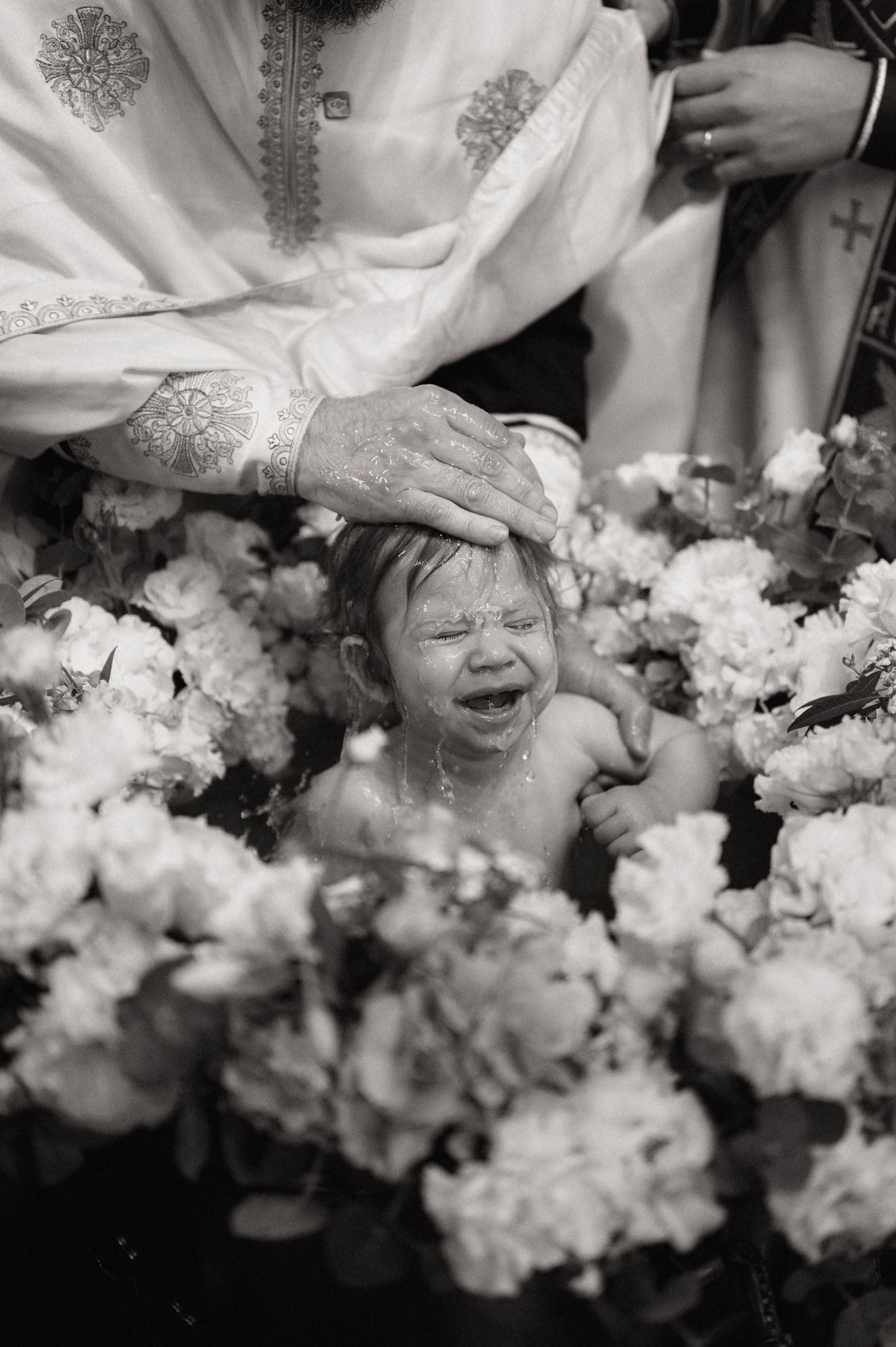Black and white photo of wedding bouquets with white flowers arranged in a row during a celebration.