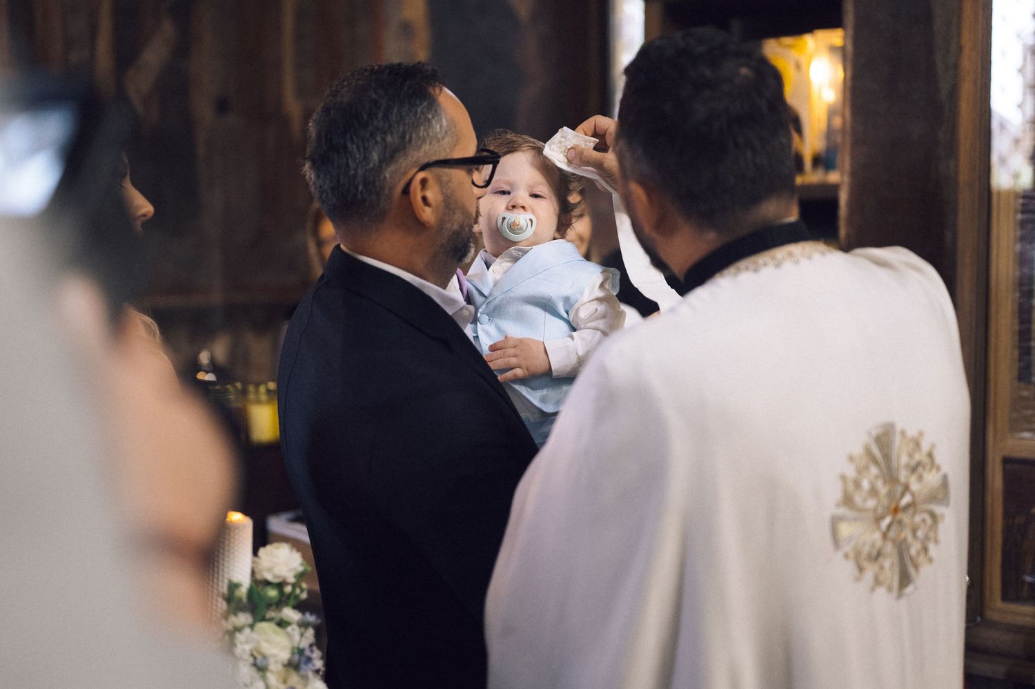 A couple in traditional wedding attire share a tender moment during their Catholic church ceremony.