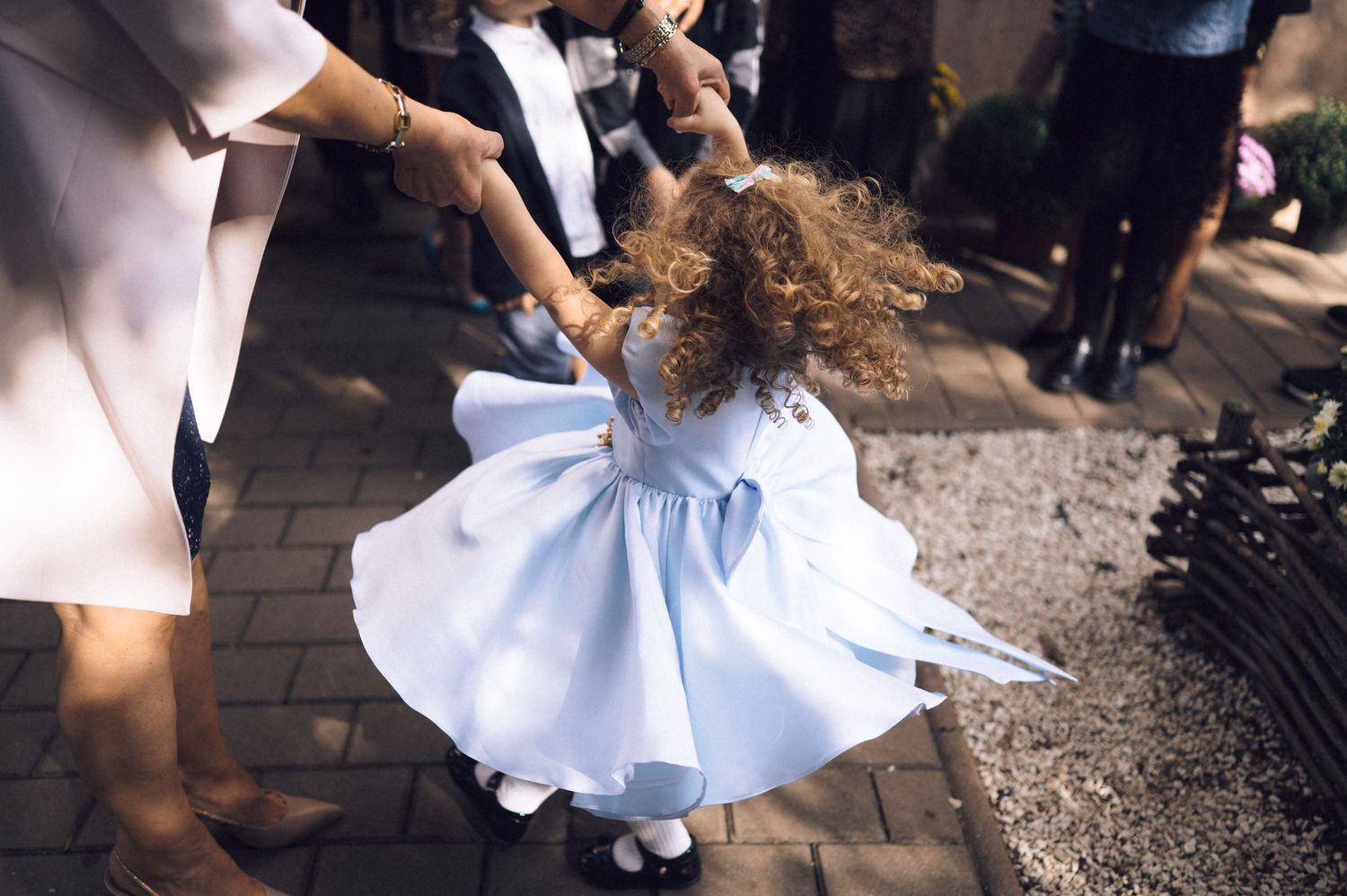 White dress flowing in motion against a dark cobblestone street during an outdoor photoshoot.