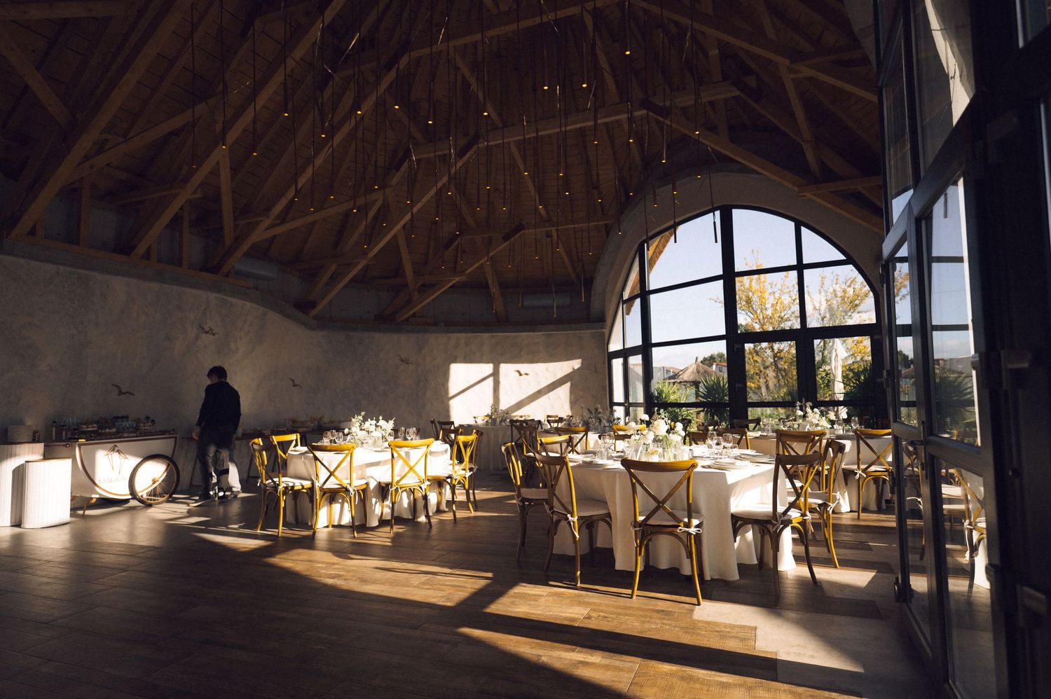 Panoramic view of a modern museum interior with vaulted wooden ceiling and illuminated display cases.