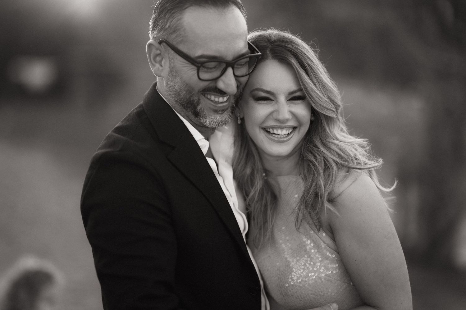 A black and white photo collage shows a happy couple laughing and embracing during a wedding celebration.