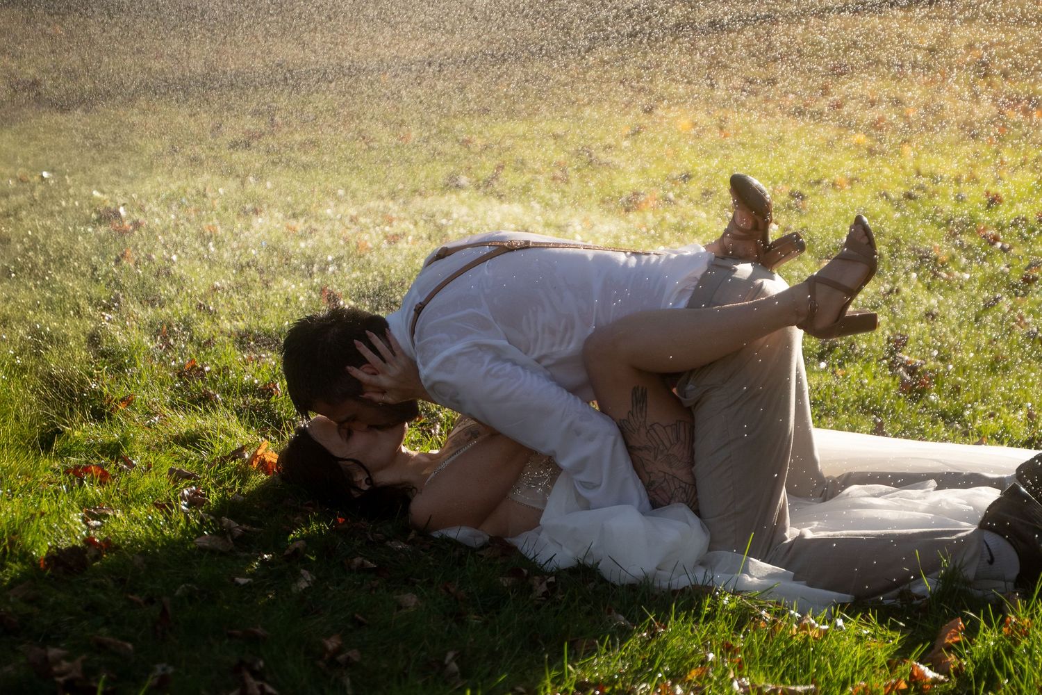 Wedding couple lying in grass during golden hour photoshoot.