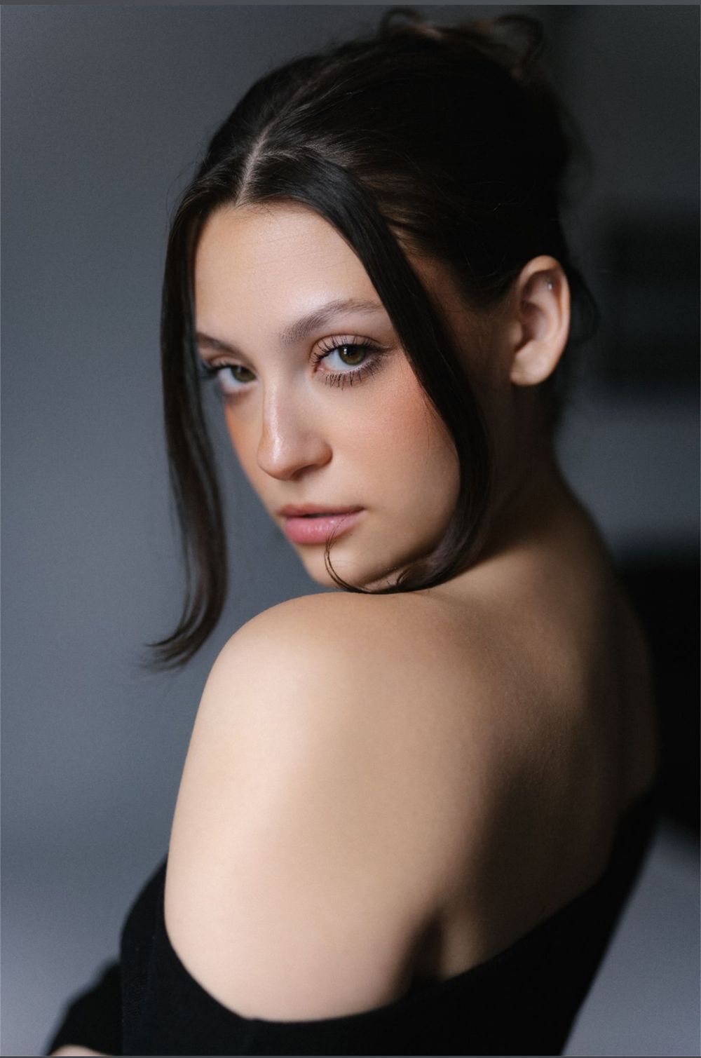 Artistic portrait series showing dramatic angles of a person with dark hair against a gray background.