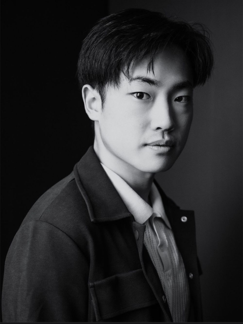 Black and white portrait series showing different angles of a person in a dark coat against a dark background.