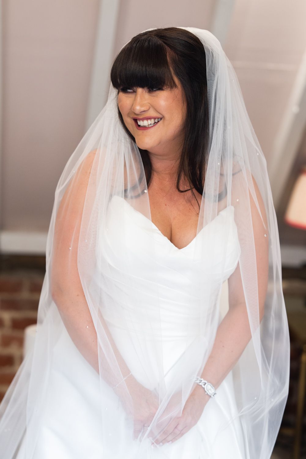 A bride in a classic white wedding dress and flowing veil smiles in a series of cropped portrait photos.