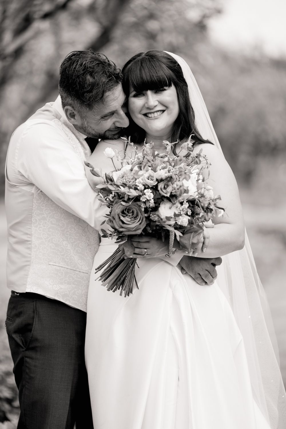 Black and white wedding photos showing intimate moments between newlyweds with floral bouquets.