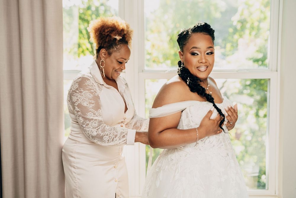 A bride and her mother share a joyful moment while getting ready for the wedding ceremony.