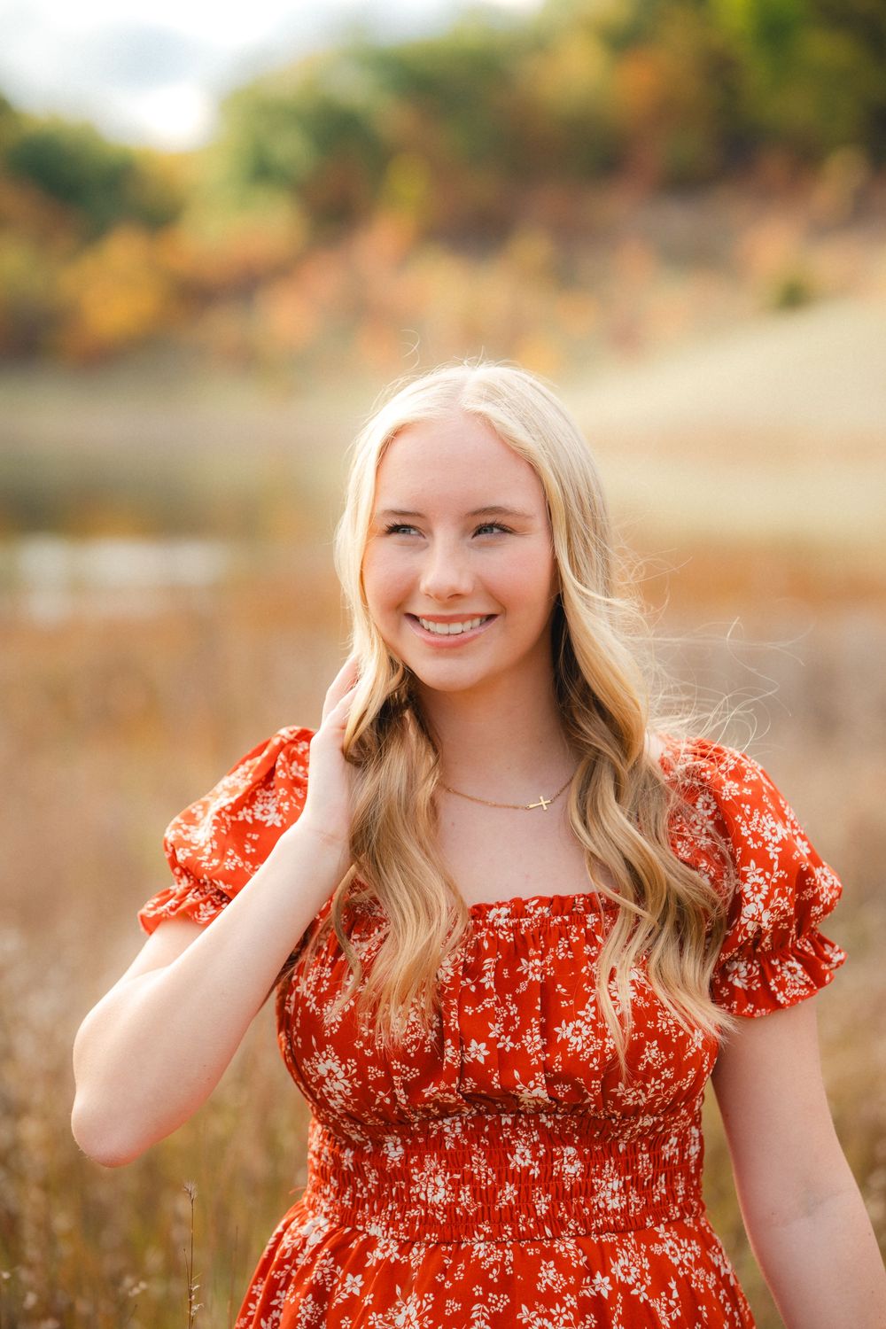 A bright red floral dress stands out against a warm autumn backdrop in a series of outdoor portrait shots.