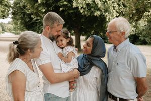 A series of candid black and white wedding photos showing tender moments between loved ones during an outdoor celebration.