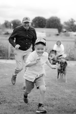 Black and white sequence of a joyful child running and playing outdoors in a grassy field.