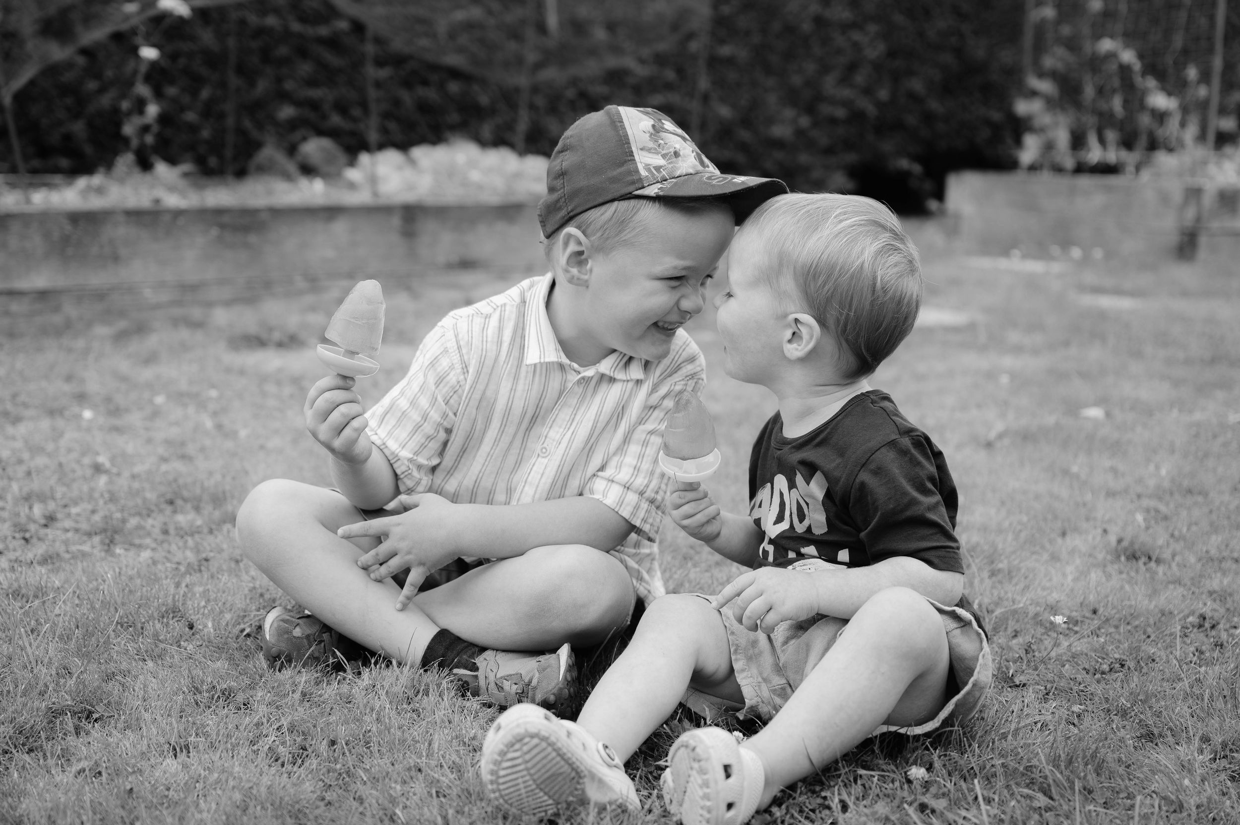 A black and white photo sequence shows a couple lying in grass sharing sweet romantic moments together.