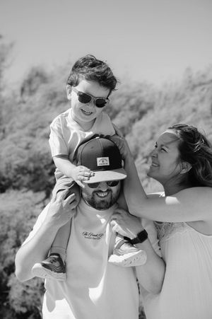 Black and white photo series showing joyful outdoor family moments with playful interactions in natural lighting.