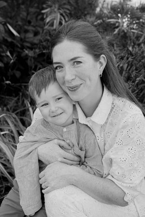 A black and white photo series shows tender moments of affection and laughter between two people in a garden setting.
