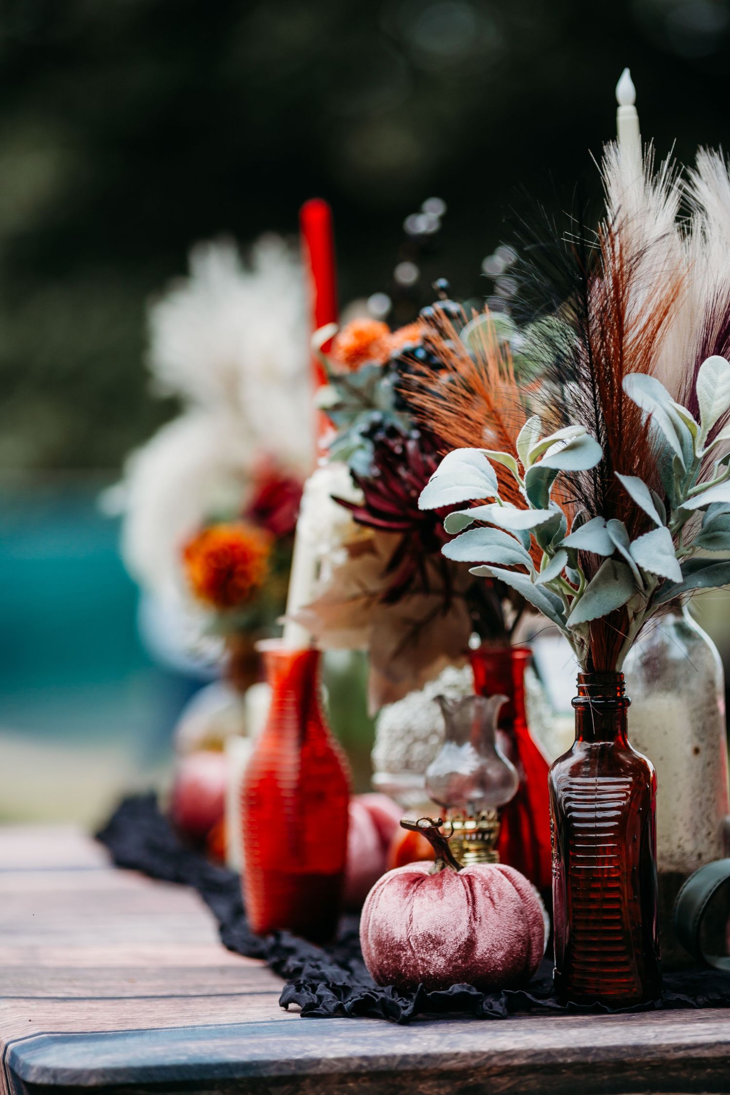 Vintage glass bottles and feathers arranged in a decorative display with soft focus and moody lighting.