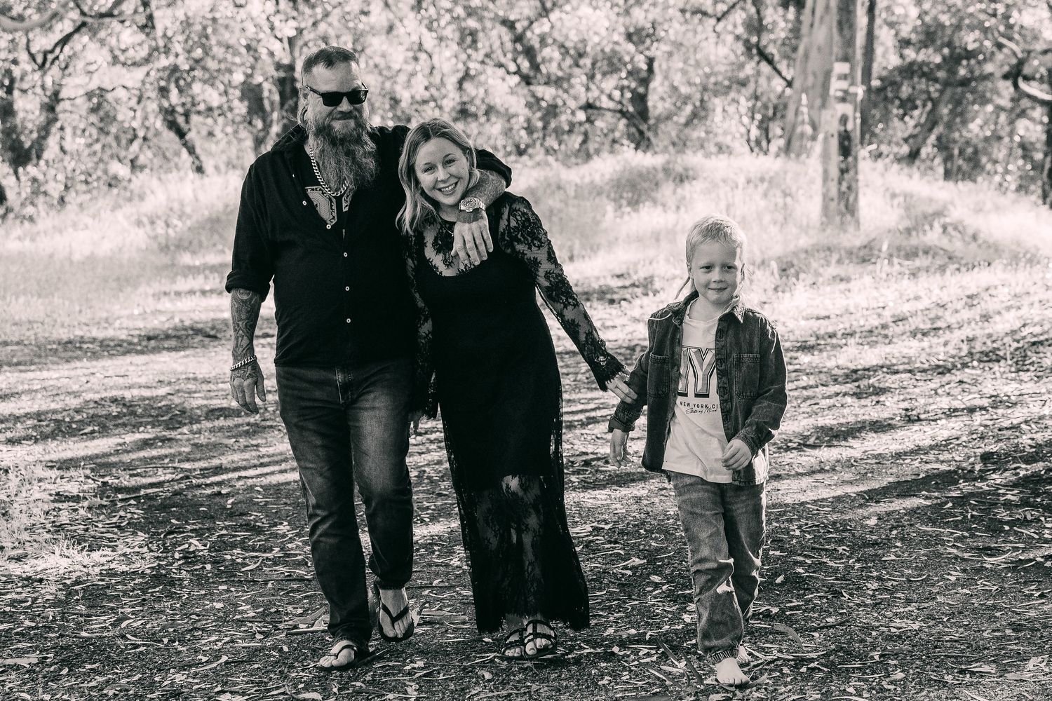 A group walks together on a wooded path during a fall day in black and white.
