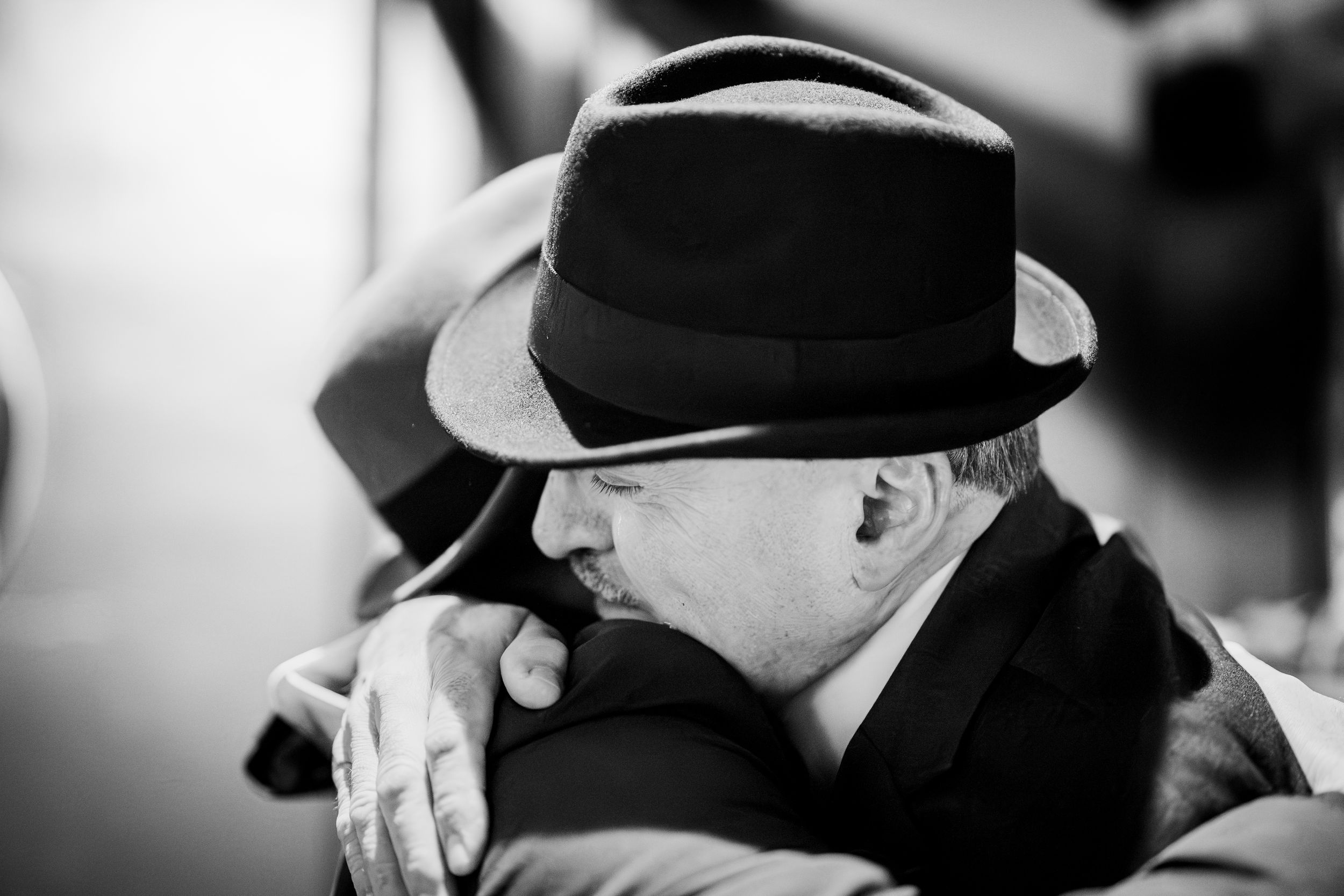 A black and white montage of people wearing fedora hats in vintage film noir style.