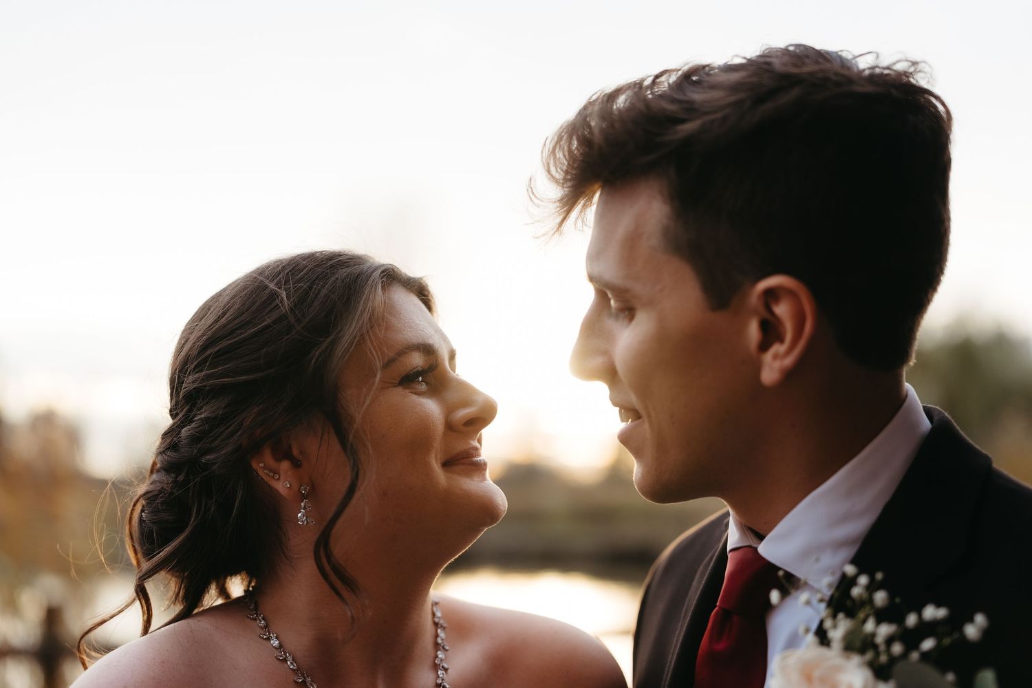 A romantic close up photo of a couple about to kiss at their wedding outdoors.