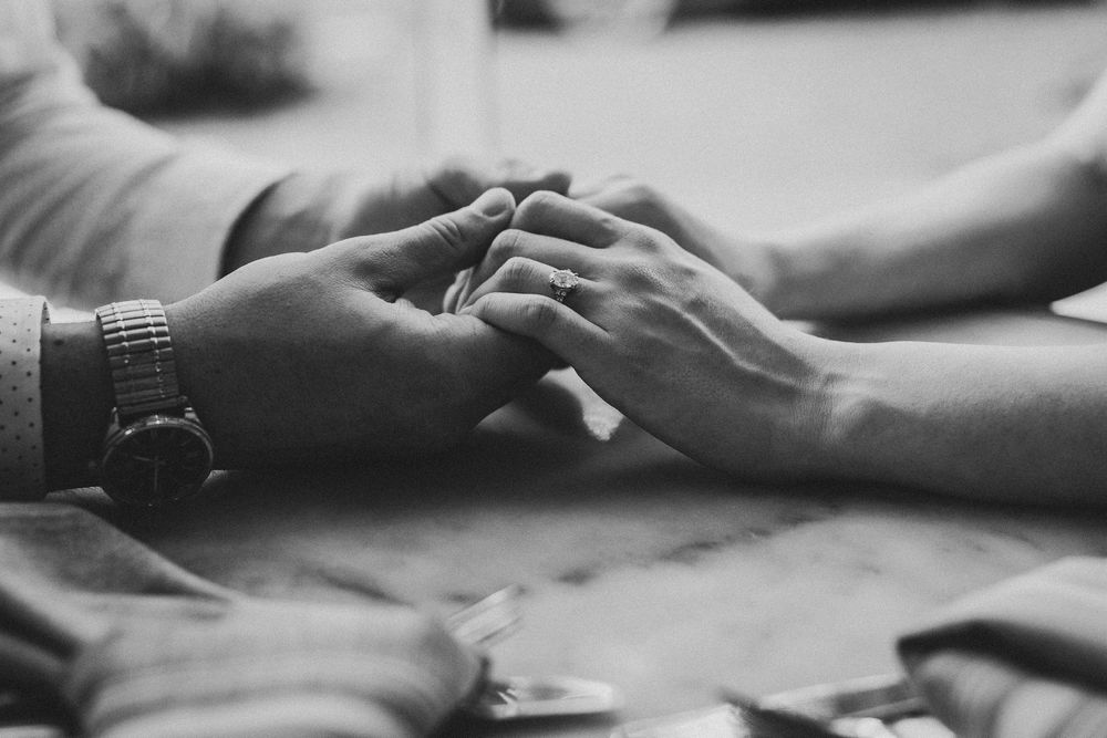 Close-up black and white image of hands embracing each other during engagement shoot