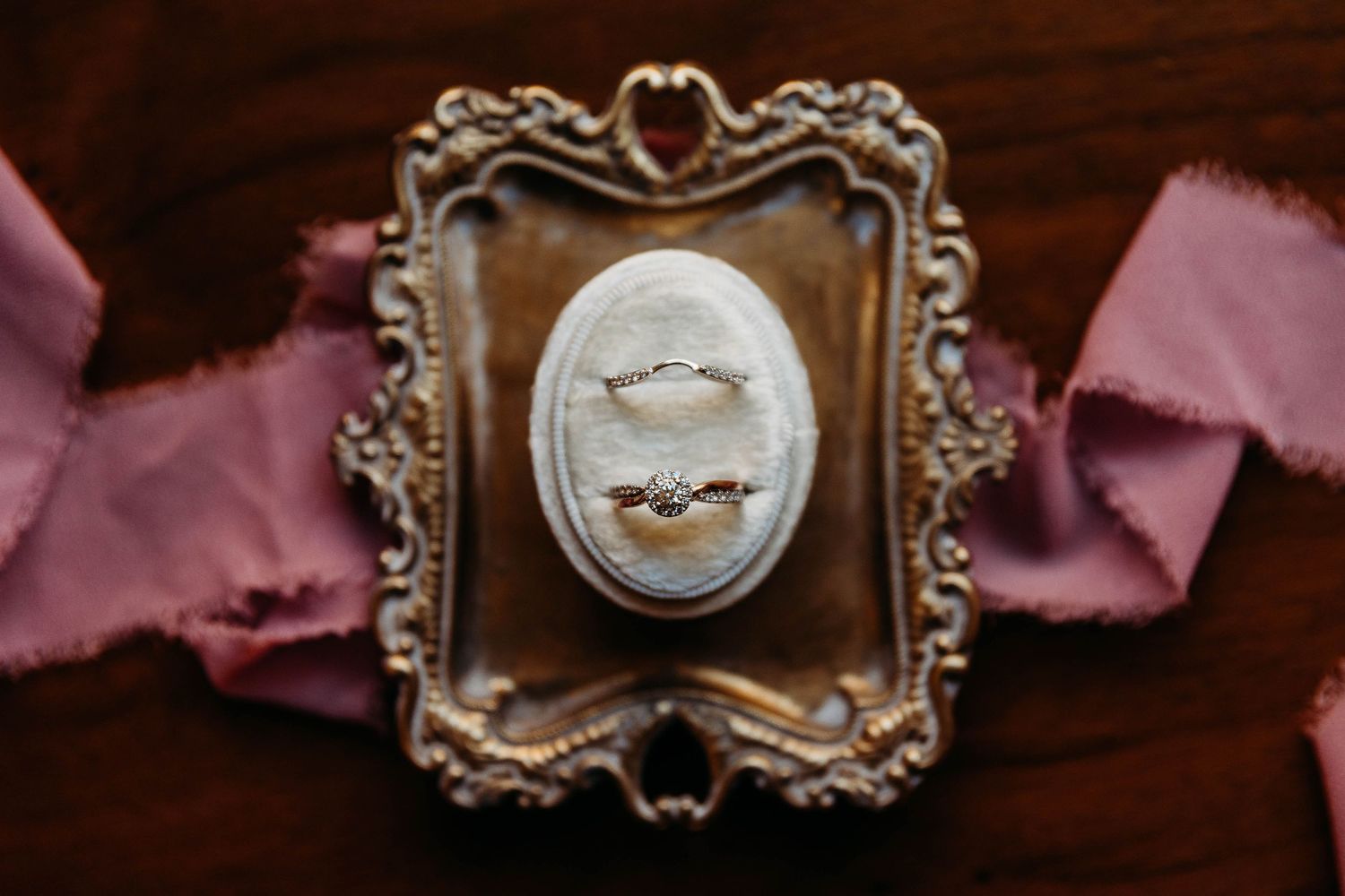 Vintage ornate gold frames with delicate baroque details hang on a dark wall creating an elegant display.