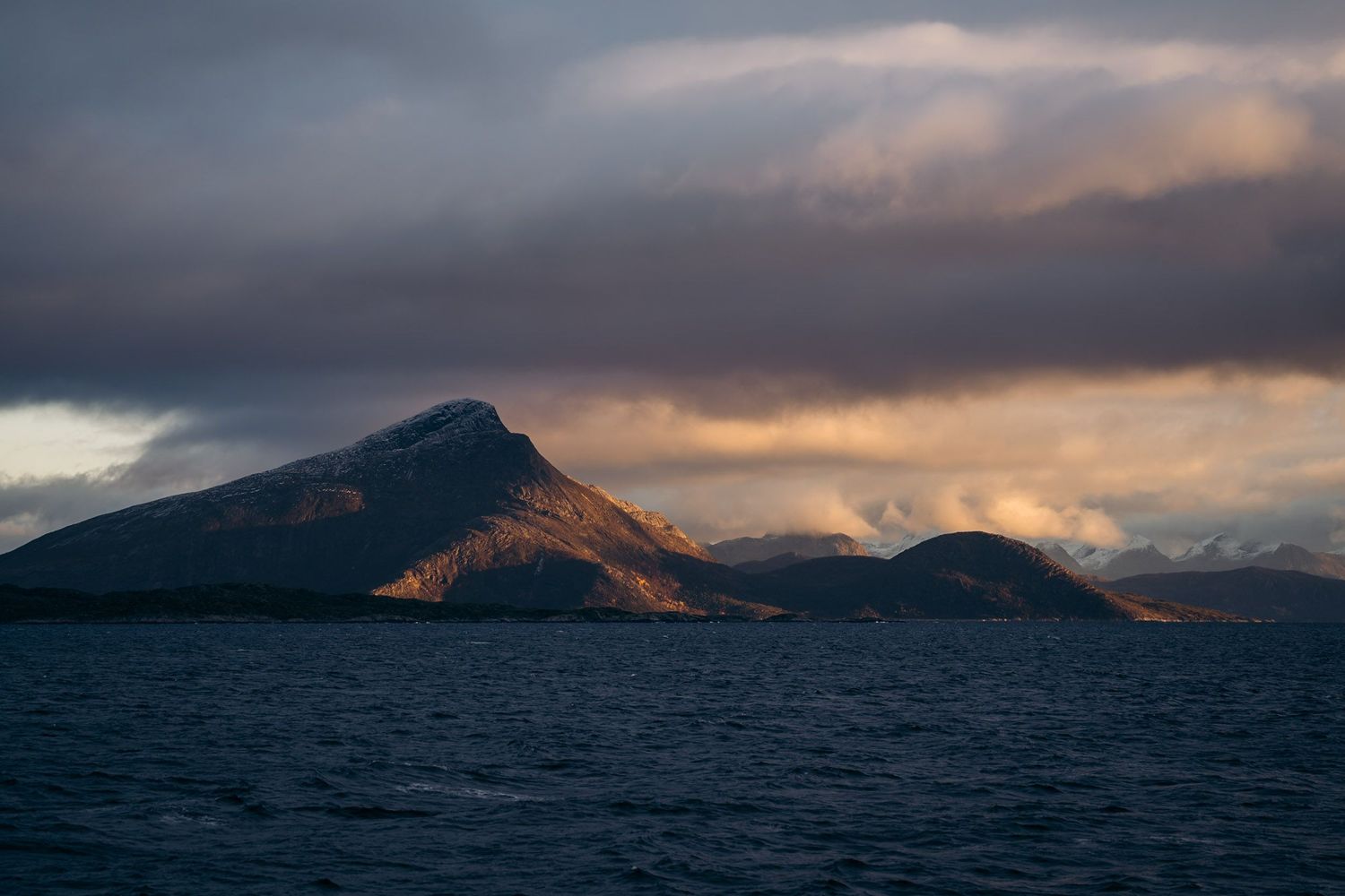 lumière orangée sur les montagnes et fjords norvégiens