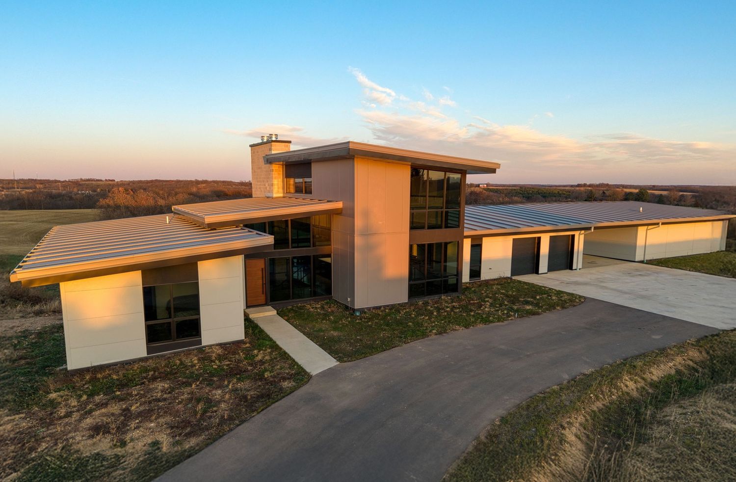 Twilight exterior photo of a modern flat-roof home overlooking open fields, Wisconsin
