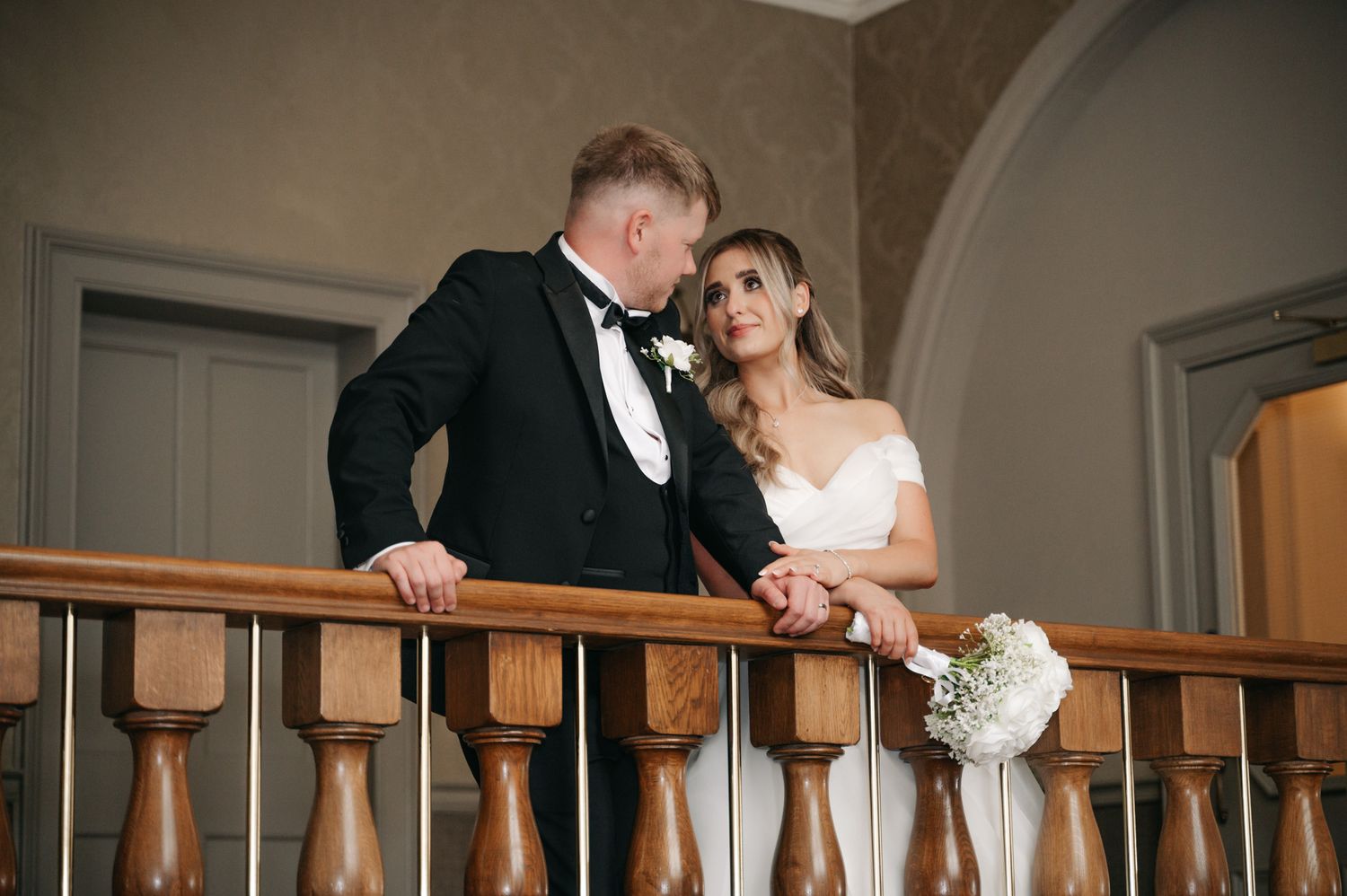 A couple shares a romantic moment during their wedding celebration in an elegant indoor venue. Wedding Photography.