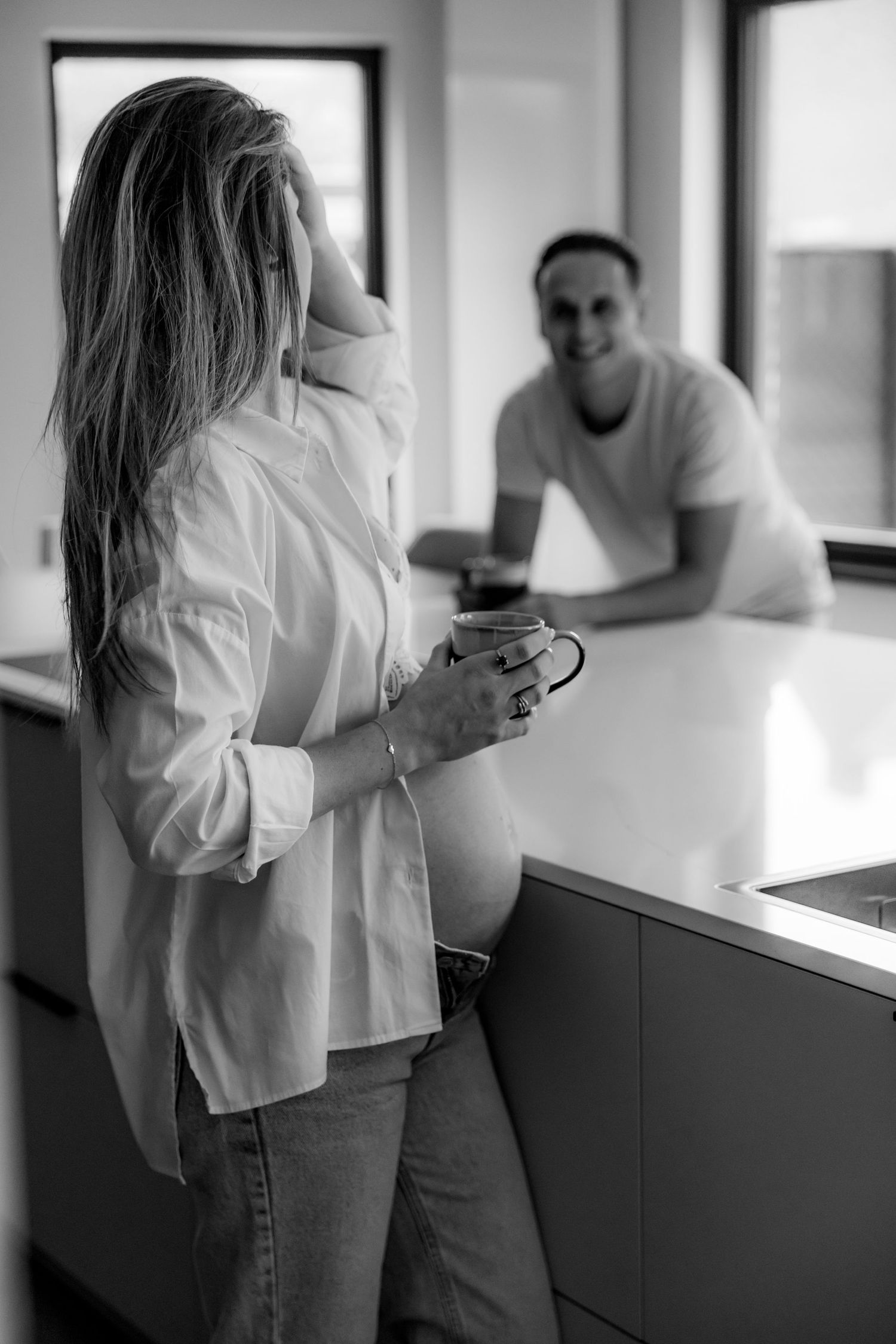 Series of romantic black and white photographs showing a couple in casual attire by a window.