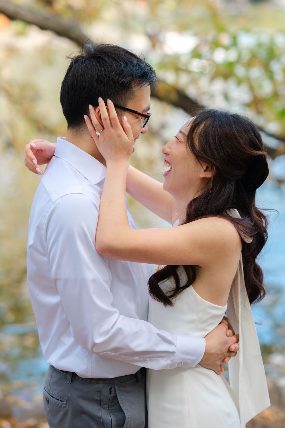 Romantic couple in white and grey attire sharing intimate moments outdoors.