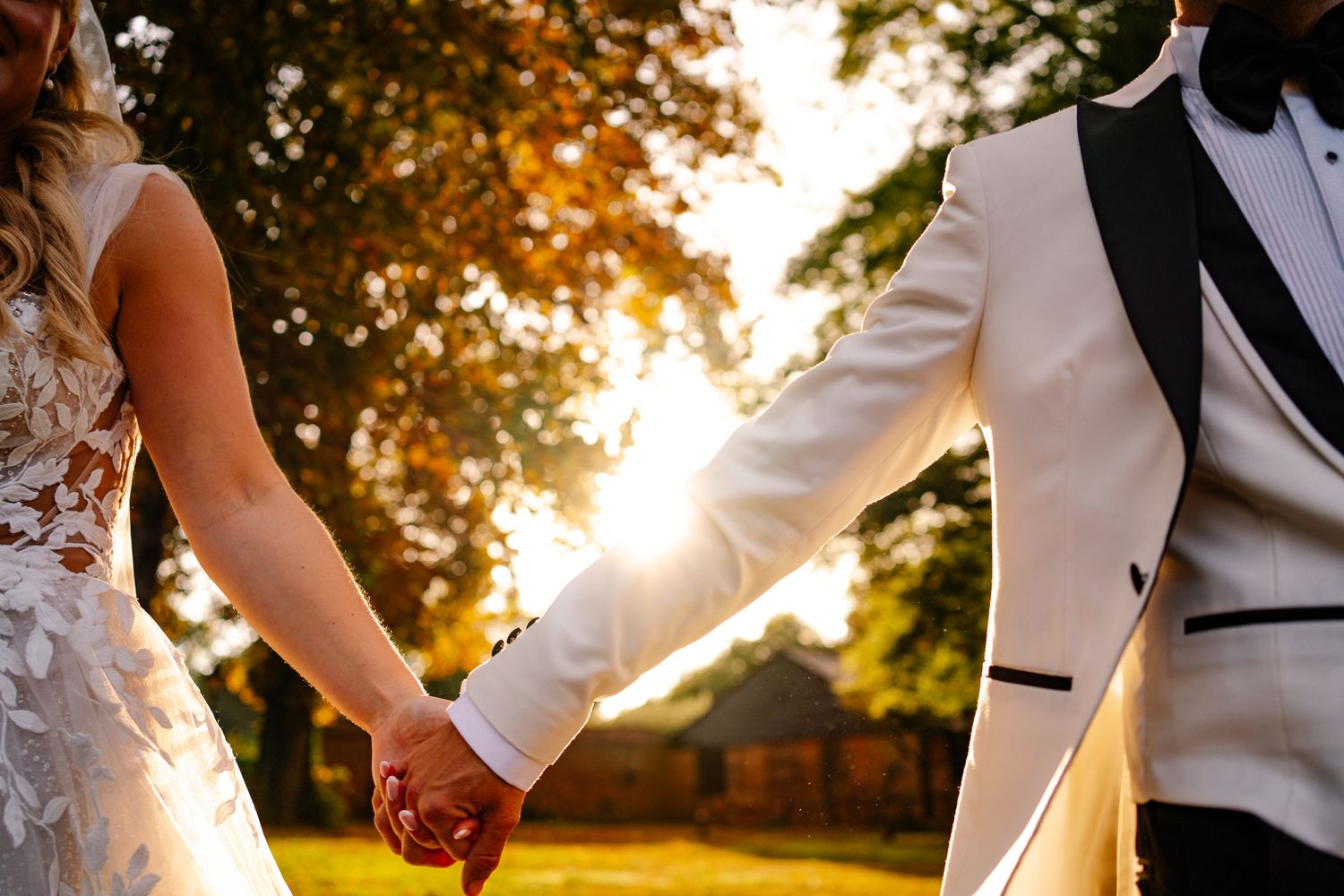 Bride and groom laughing together holding hands during golden hour couple portraits at a Hampshire wedding