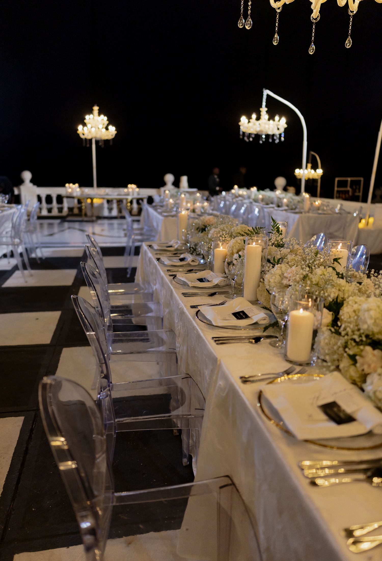 Luxurious wedding reception hall with crystal chandeliers and elegant floral wall decorations.