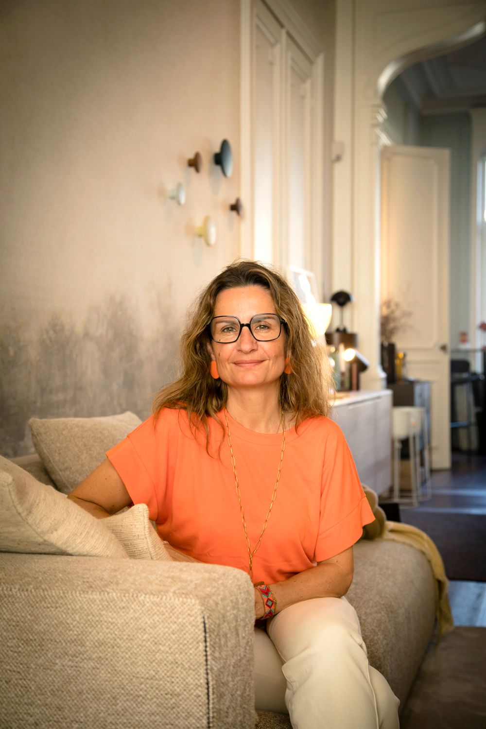 A sequence of photos shows someone in an orange shirt sitting on a gray couch with decorative butterflies on the wall.