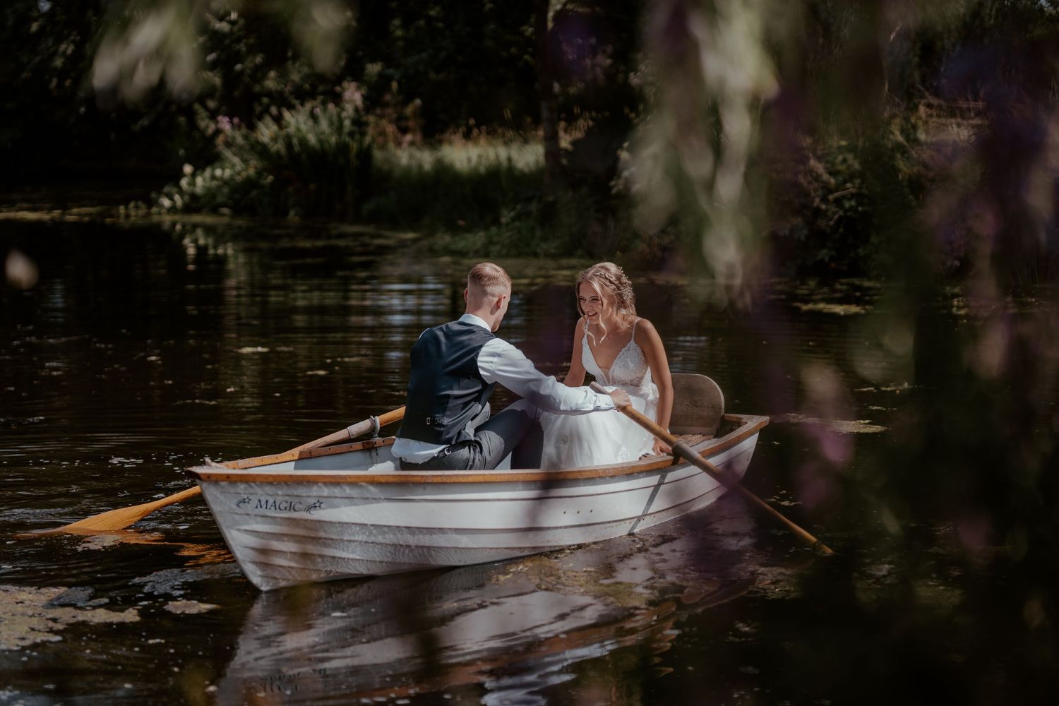 A romantic boat ride on a tranquil pond with a white rowboat reflecting in the still waters.