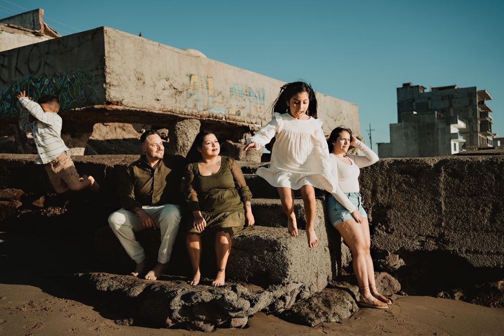 Family photo with the kids joyfully jumping in the sand
