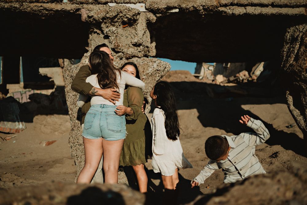 Family group hug with their son playing, capturing the love in Mazatlán